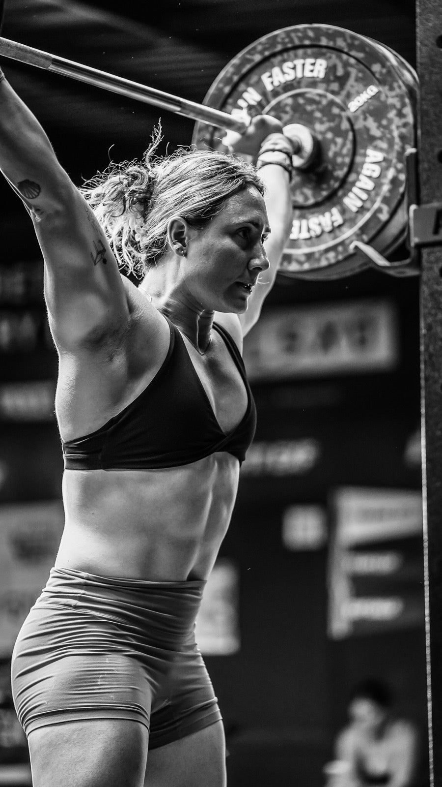 Ascend athlete pressing a barbell overhead mid-competition